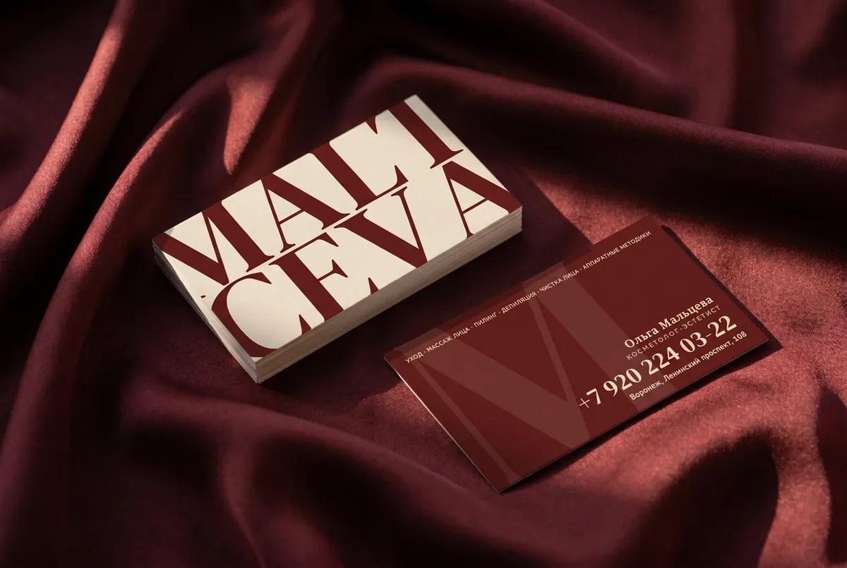Двусторонняя визитка MALTCEVA на бордовом атласе: кремовая сторона с oversized-кропом MALT/CEVA и бордовая с телефоном, набранным дидоном